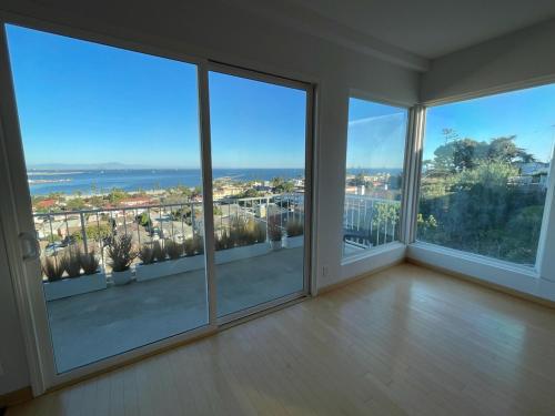 an empty living room with large windows and a view of the ocean at Mod2bd2ba ShowstoprViews. BBQ. Garage. in San Pedro
