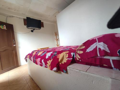 a room with a bed with a red blanket at Hotel Maeo in Montañita