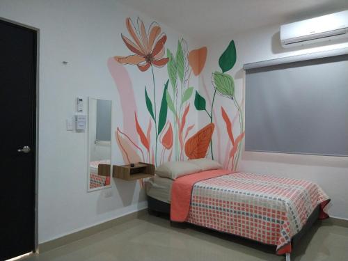 a room with a bed with a flower mural on the wall at Casa Narcisa Studio Apartaments in Mérida
