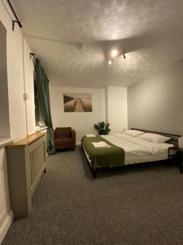 a bedroom with a bed and a couch and a television at Cold Harbour Entire 3 Bed House - Free Parking in Croydon