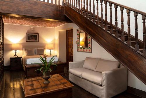 a living room with a bed and a staircase at Posada del Tepozteco - Hotel & Gallery in Tepoztlán