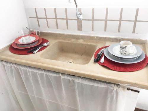 a sink with plates and coffee cups on it at Loft em Souzas in Joaquim Egídio