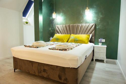 a bedroom with a large bed with yellow pillows at Kasa Nouveau in Oradea