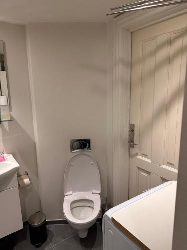 a white bathroom with a toilet and a sink at Aarhus lejlighed med udsigt in Aarhus