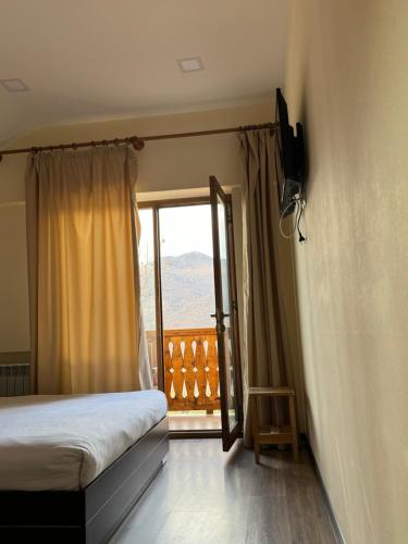 a bedroom with a bed and a window with a view at Verin Tun in Dilijan