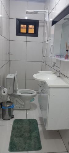 La salle de bains est pourvue de toilettes, d'un lavabo et d'un miroir. dans l'établissement Pousada do Sidão, à Estivado
