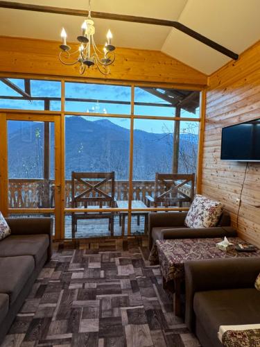 a living room with couches and a television and a table at Verin Tun in Dilijan