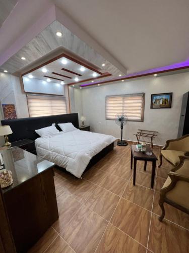 a bedroom with a large bed and a couch at Petra balcony apartment in Wadi Musa