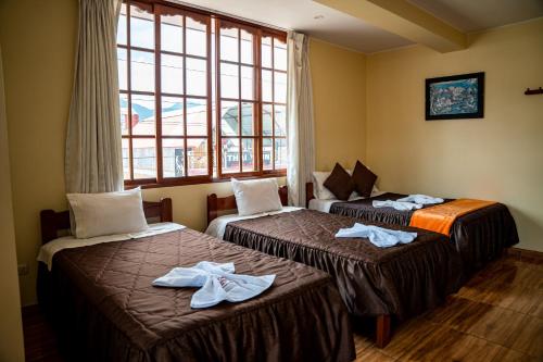 a hotel room with two beds and a window at Hospedaje Chimy in Oxapampa