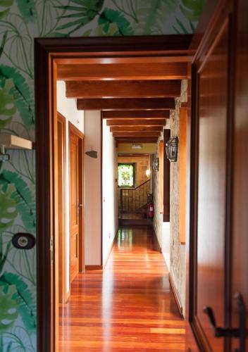 a hallway of a home with wooden floors and green wallpaper at Casa de Costoia in Santiago de Compostela