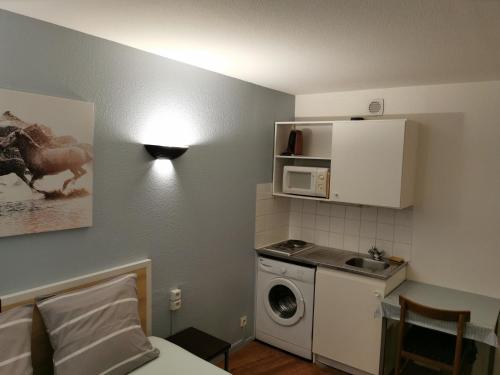 een kleine keuken met een wasmachine en een magnetron bij Appart Hotel La Defense in Courbevoie