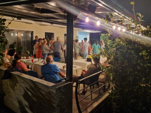 a group of people sitting at tables in a restaurant at Apartments Picioski in Peštani