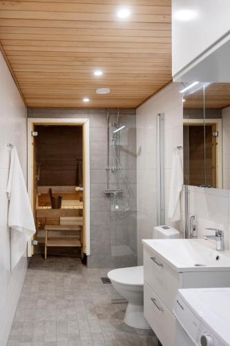 a bathroom with a shower and a toilet and a sink at Viola apartments in Rovaniemi