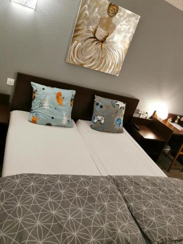 a bedroom with a bed with pillows and a picture on the wall at Appart Hotel La Defense in Courbevoie