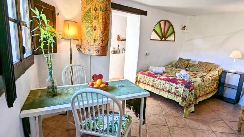 a room with a bed and a table and chairs at Casa Mariposa in Casares