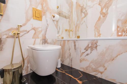 a white toilet in a bathroom with marble walls at LUX Апартаменти MYFREEDOM поруч метро Театральна, Хрещатик in Kyiv