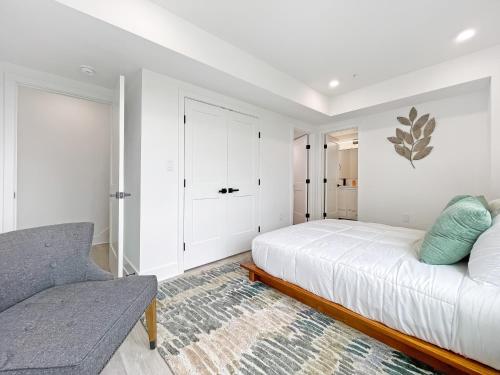 a white bedroom with a bed and a couch at Mary's Stay Brookland in Washington