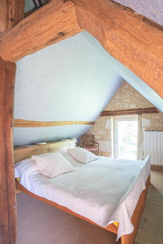 a bed in a room with a wooden frame at Séjour au Moulin de Boiscorde, Le Perche in Rémalard