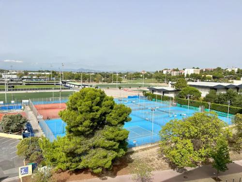 - une vue sur un court de tennis avec des courts bleus dans l'établissement La Halte Catalane, à Perpignan