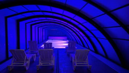a row of chairs in a tunnel with blue lights at Dobre smaki at Wczasowa8 sea resort in Sarbinowo
