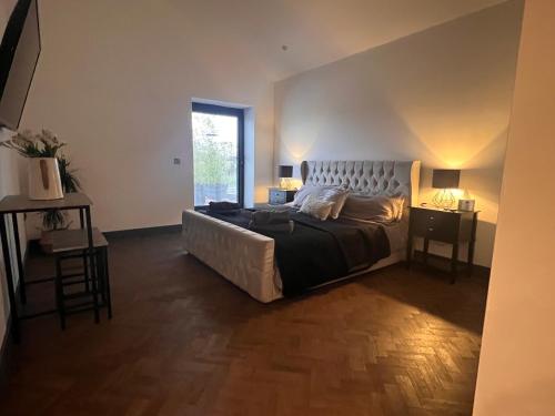 um quarto com uma cama grande e uma janela em Marmalade Barn Guest Suite with wet room em Rugeley