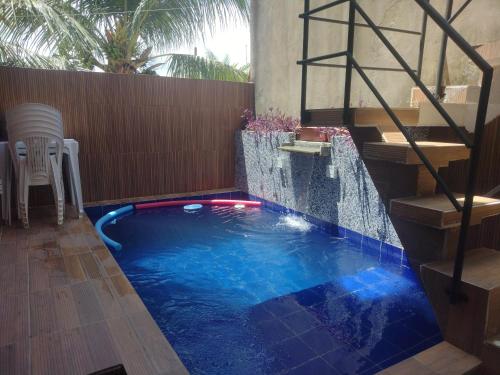 a swimming pool with a waterfall in a backyard at Casa de praia Rocha Alves em Porto de Galinhas in Porto De Galinhas