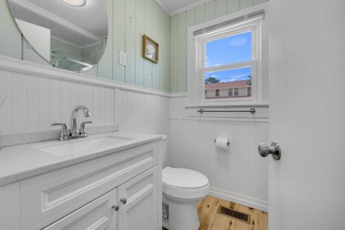 a bathroom with a toilet and a sink and a window at 200ft to beach! North Myrtle Beach first level duplex home, pet friendly! in Myrtle Beach