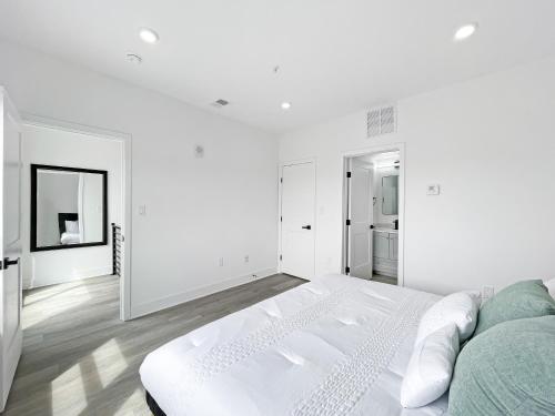 a white bedroom with a bed and a mirror at Mary's Stay Brookland in Washington
