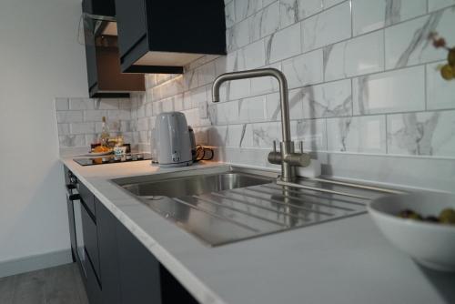 a kitchen with a sink and a counter top at Station Road Stays - 1 & 2 bed apartments - Desborough, Kettering in Kettering
