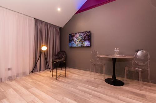a room with a table and chairs and a painting on the wall at LUX Апартаменти MYFREEDOM поруч метро Театральна, Хрещатик in Kyiv