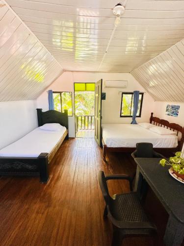 a room with two beds and a table and chairs at Surf Paradise in Santa Teresa Beach