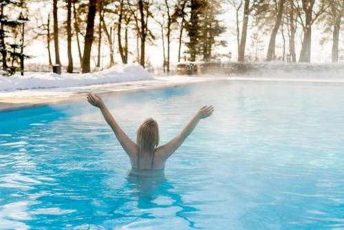 a woman in a swimming pool with her arms up at Holiday Inn Express Boise Downtown by IHG in Boise