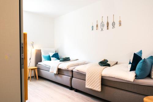 two beds in a room with blue pillows at Luxuswohnung am Steinhuder Meer - Tierfreundlich - B in Wunstorf