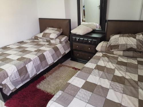 a bedroom with two beds and a dresser and a mirror at Roxy -Heliopolis in Cairo