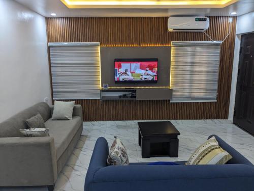 a living room with a couch and a tv at Easyinn Shortlet Apartment in Port Harcourt