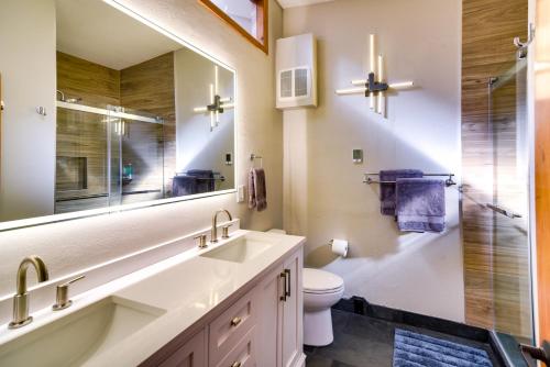 ein Badezimmer mit einem Waschbecken, einem WC und einem Spiegel in der Unterkunft Winter Park Townhome with Hot Tub, Half Mi to Dtwn! in Winter Park