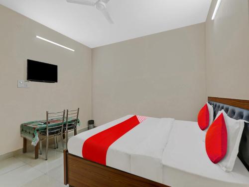a bedroom with a bed and a table and a television at OYO Flagship 81216 Hotel Silver Grand in Lucknow