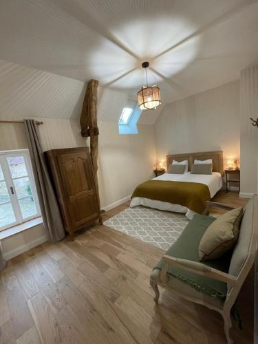 1 dormitorio con cama y sofá en Gîte du fournil « Chez Nicole », en Ully-Saint-Georges
