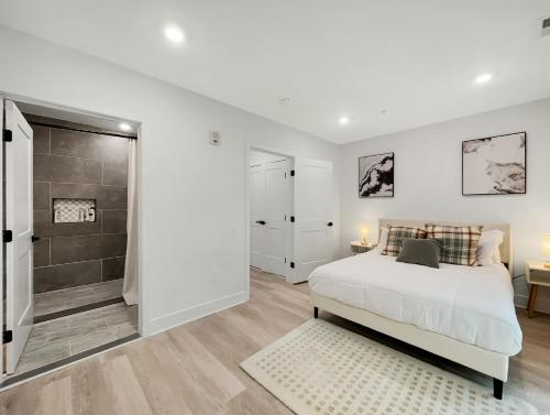a white bedroom with a bed and a shower at Mary's Stay Brookland in Washington