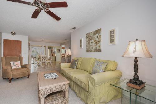 a living room with a couch and a ceiling fan at Beautifully updated bright and cheery 2nd story condo near pool beach access- SC261 in Edgewater