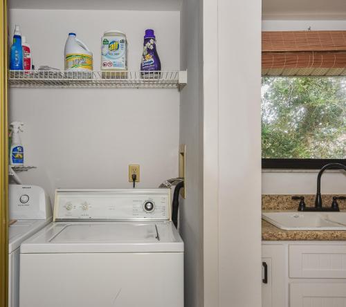 a kitchen with a white dishwasher next to a sink at Beautifully updated bright and cheery 2nd story condo near pool beach access- SC261 in Edgewater