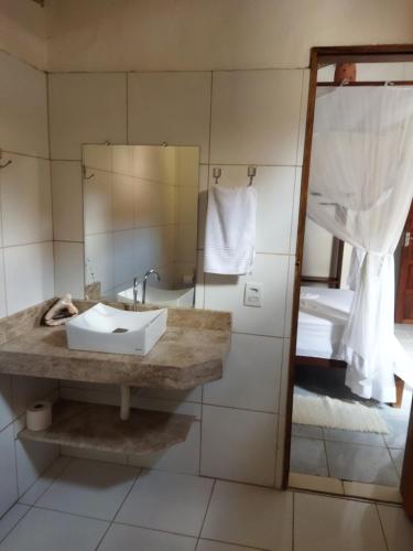 a bathroom with a sink and a mirror at Casa da Drica Trancoso in Trancoso