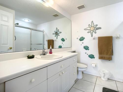ein Badezimmer mit Waschbecken, Toilette und Spiegel in der Unterkunft Beautiful 3 bedroom 2 bath condo with Breath taking views of the ocean. OW1-407 in New Smyrna Beach
