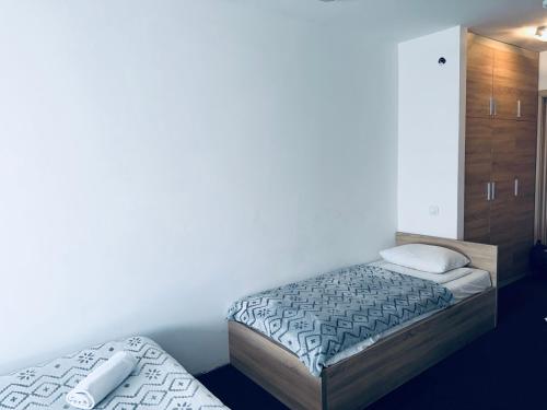 two beds in a room with white walls at Apartman Masa Kopaonik in Kopaonik