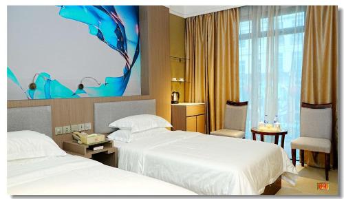a hotel room with two beds and a fish painting on the wall at pristine 1 in Manila