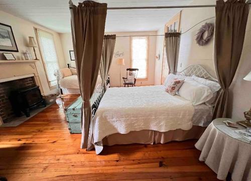 um quarto com uma cama grande e uma lareira em Historic Seaton Springs Farm B&B - James Tipton En-Suite Triple Room em Sevierville