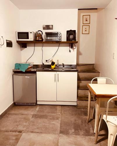 a small kitchen with a sink and a table at Marcel de Buenos Aires in Buenos Aires
