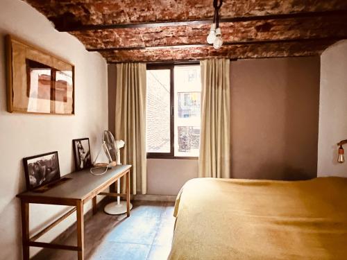 a bedroom with a bed and a desk and a window at Marcel de Buenos Aires in Buenos Aires