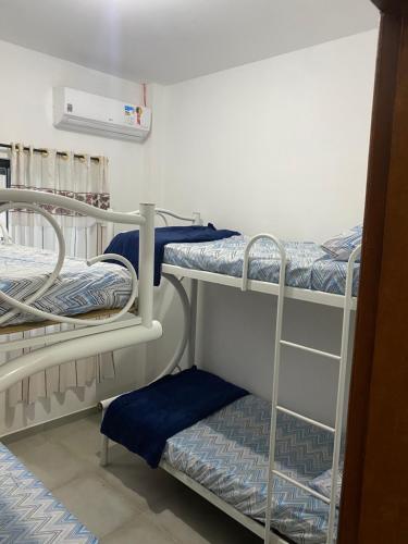 a room with two bunk beds in a room at Aconchegante Casa de praia in Matinhos