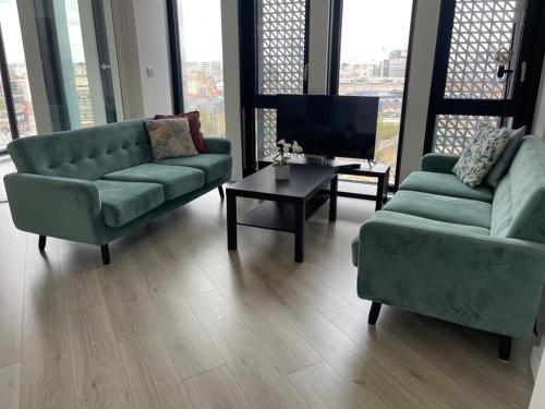 a living room with two couches and a tv at Manhattan Pad in London